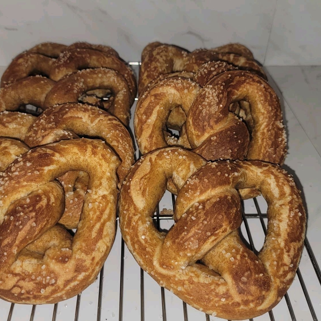 Salted soft pretzels cooling on a rack